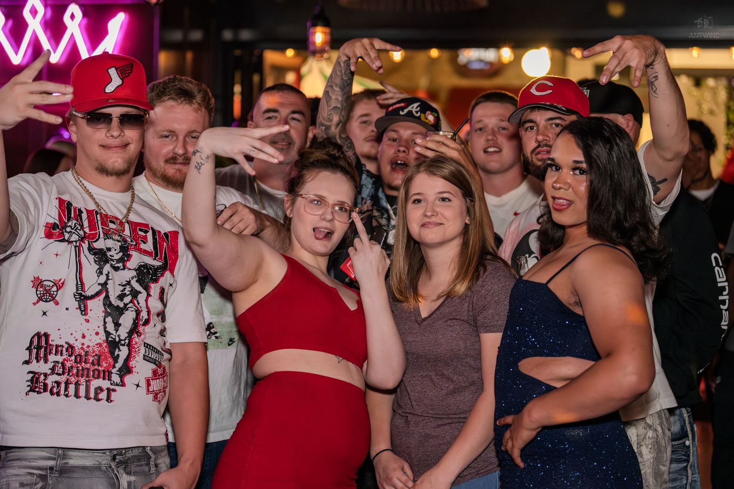 Energetic group of friends taking a selfie together at a vibrant nightclub.