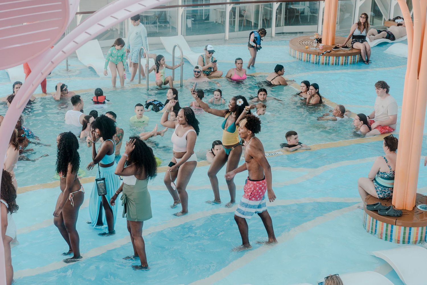 Guests enjoy a fun pool dance party activity on a cruise ship with instructors leading the group.