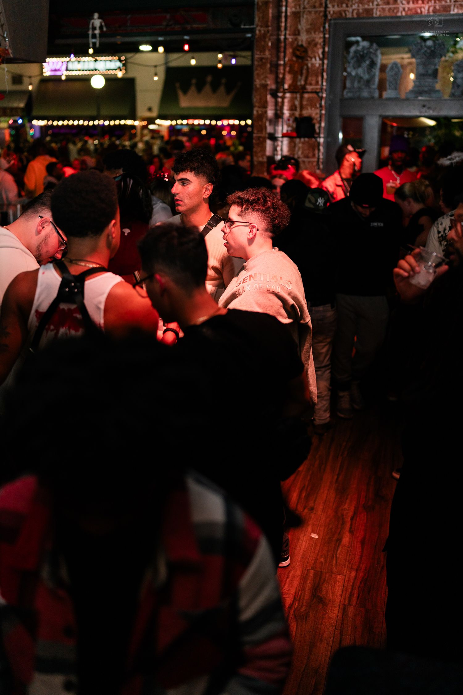 Large crowd of people dancing and socializing on a wooden dance floor at a nightclub event.