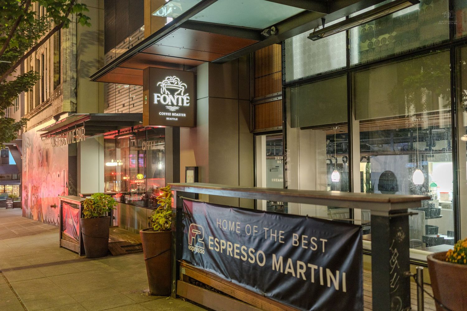 Fonte Coffee Roaster storefront at night with espresso martini banner on a city sidewalk.