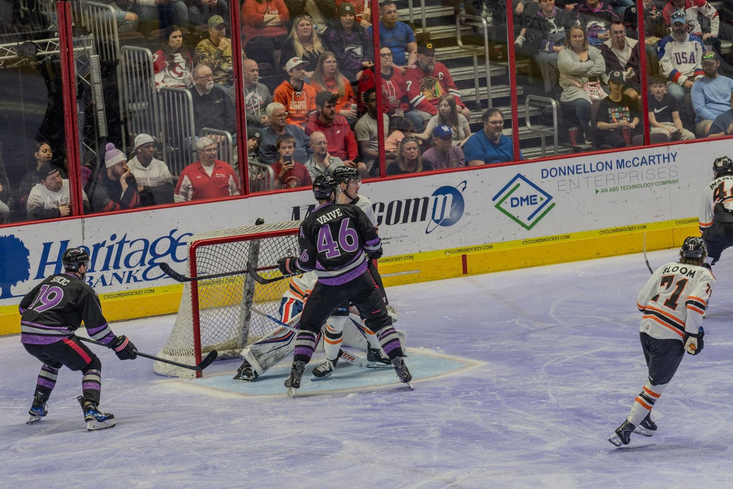 Hockey players battle in front of the net during an exciting minor league ice hockey game.