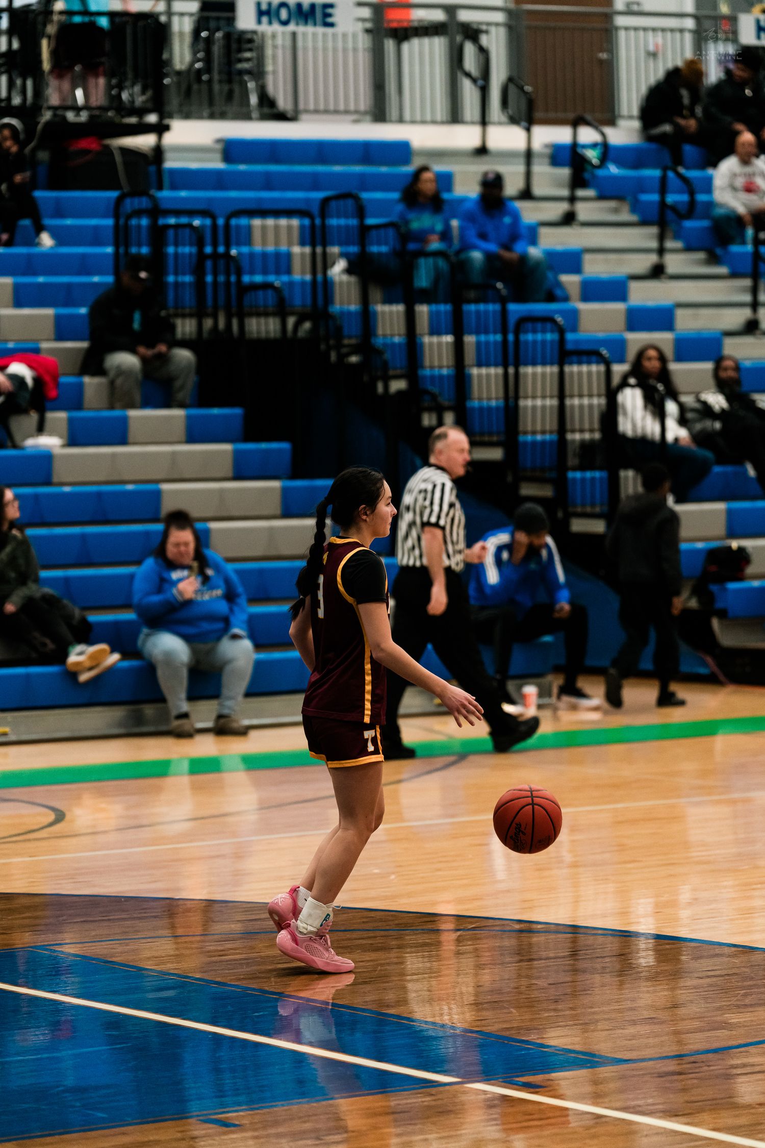 Turpin girls basketball player in maroon uniform dribbles ball during high school basketball game.