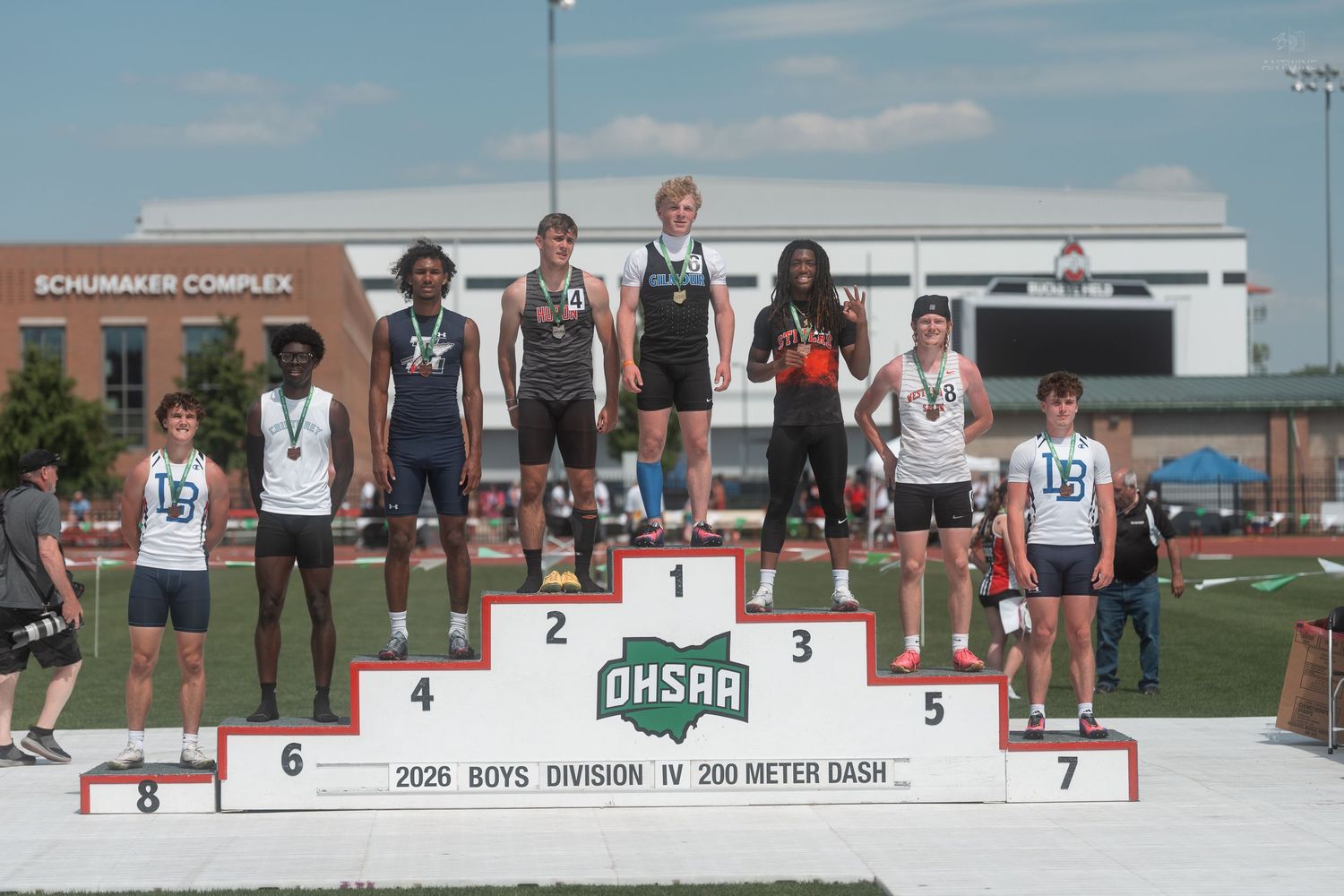 Boys Division IV 200 Meter Dash top finishers stand on the OHSAA awards podium at Schumaker Complex.