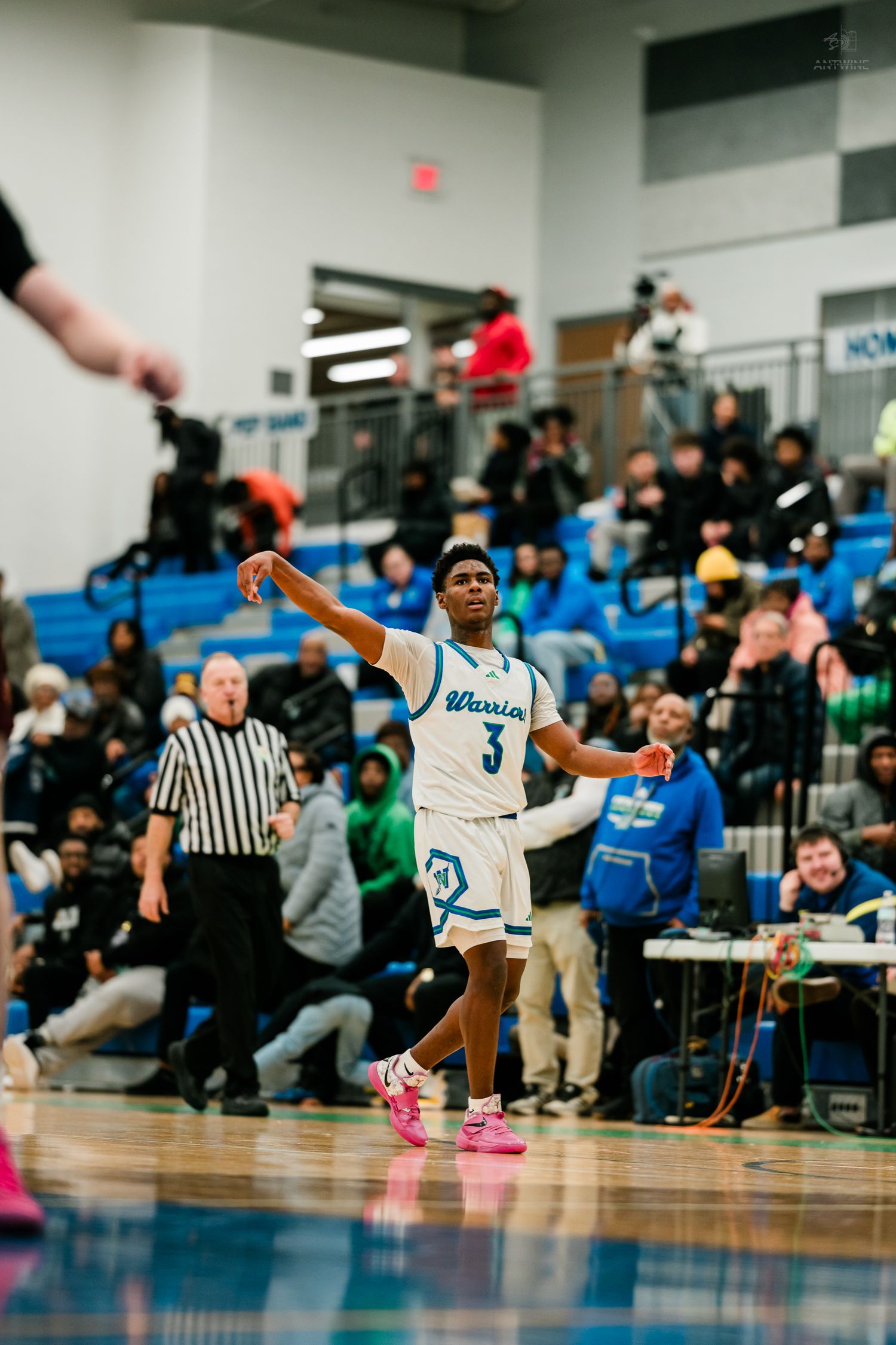Warriors player number 3 follows through on a shot wearing pink sneakers during a high school basketball game.