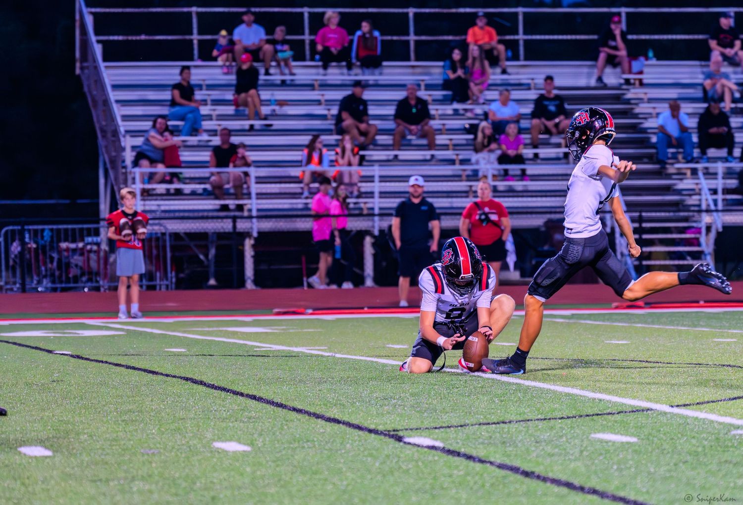 Football player makes a tackle near the sideline during a Colerain night game.
