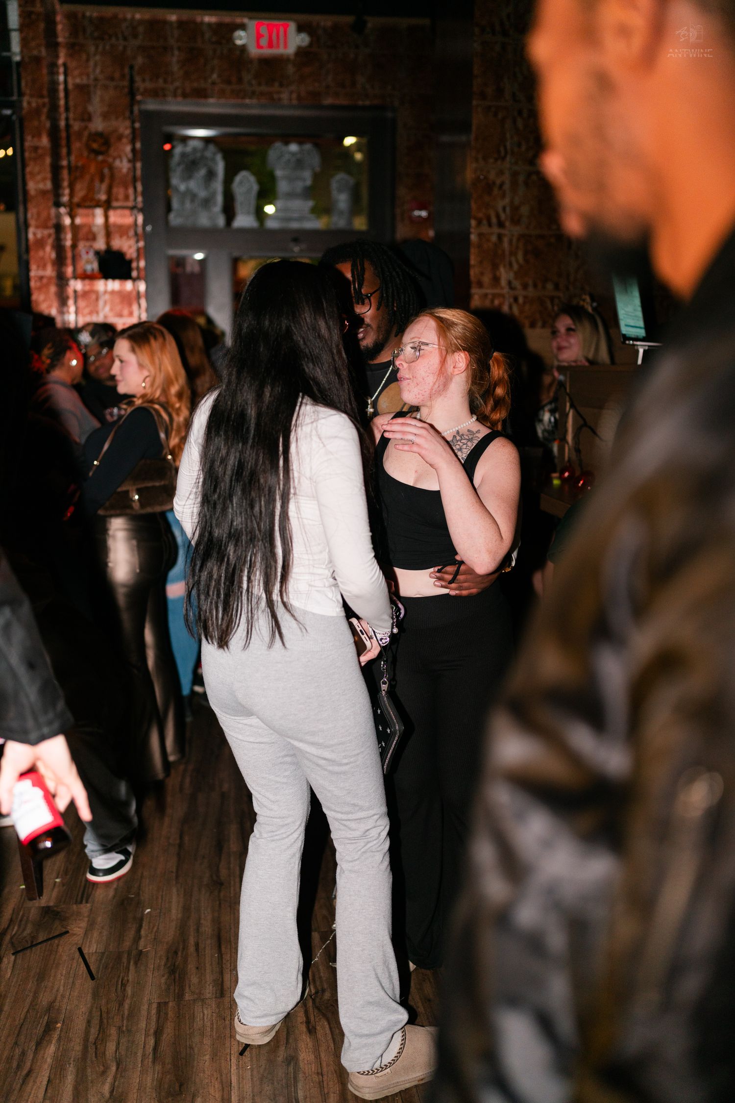 Group of people socializing and dancing together at a crowded indoor nightclub Halloween party.