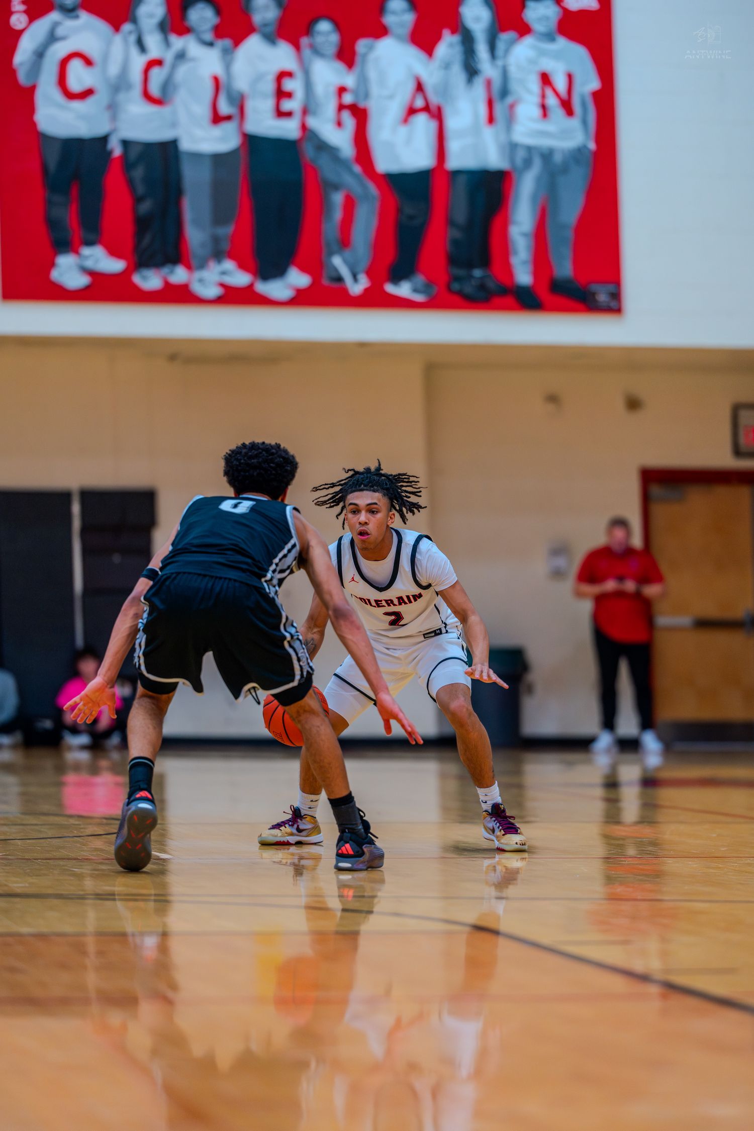 Colerain high school basketball player dribbles while being defended during an indoor game.