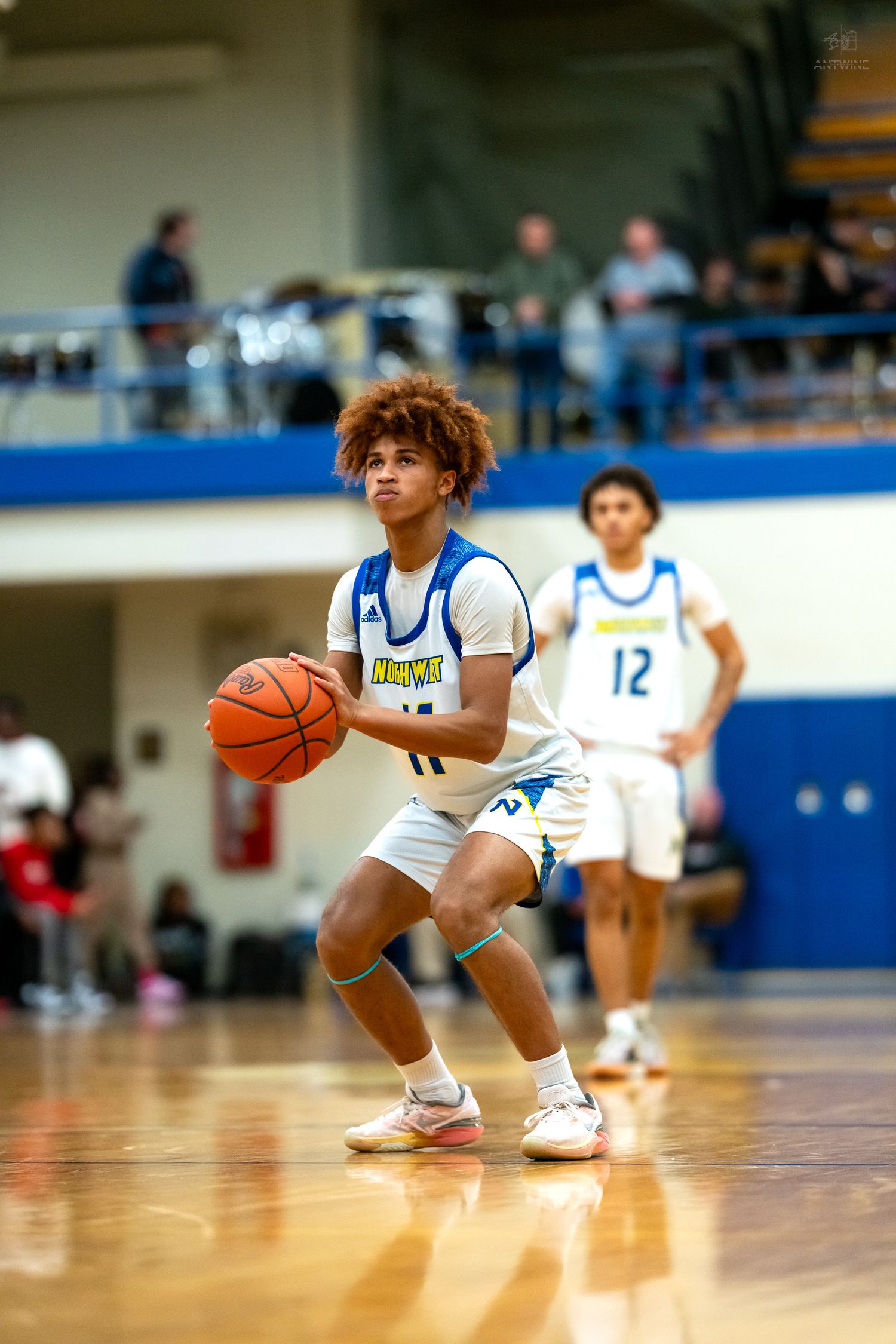 Northwest high school basketball player #11 prepares to shoot a free throw during a game.