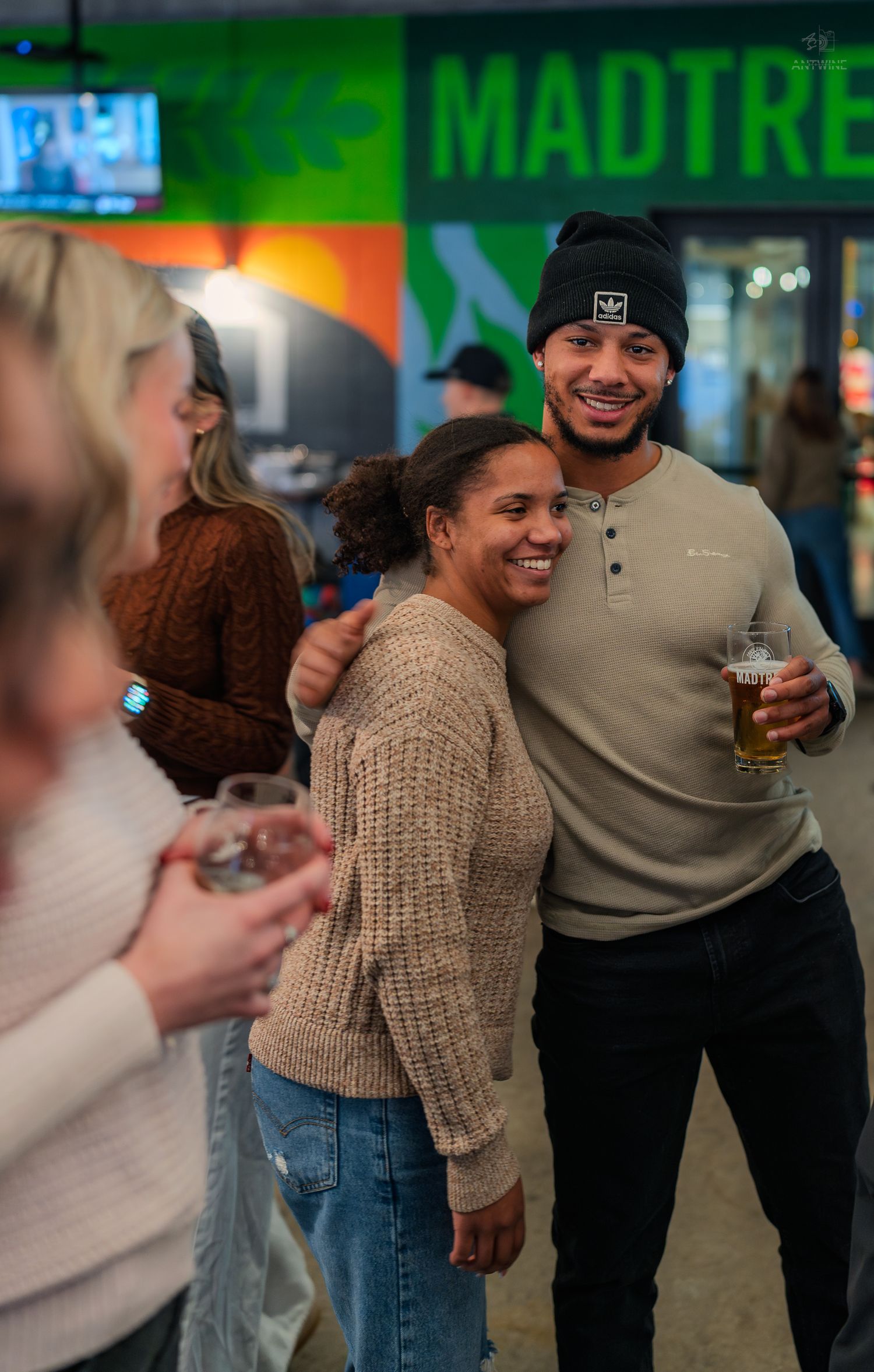 Couple smiling and posing together inside MadTree Brewing at a festive social event.