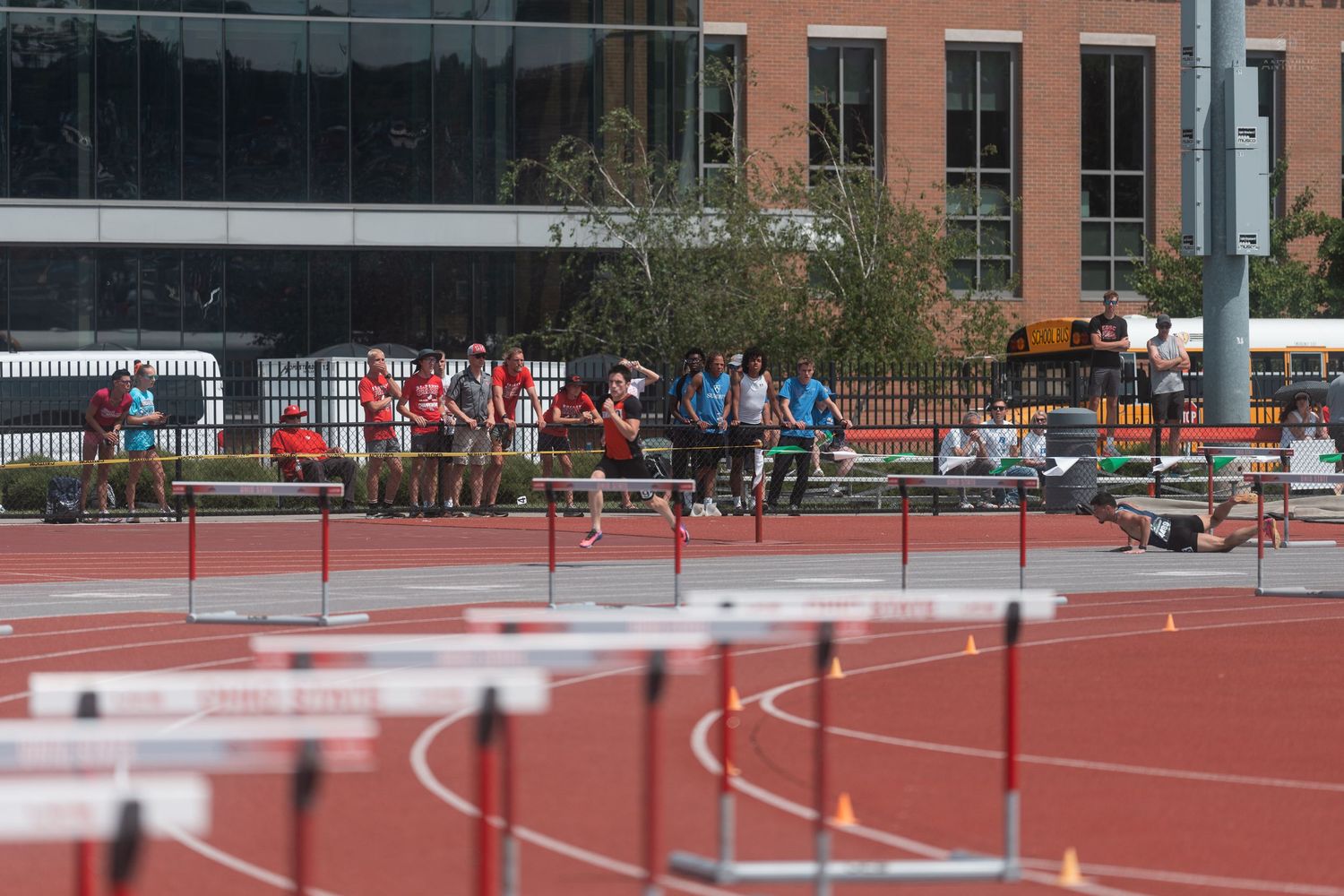 Track and field athletes prepare at the starting line for a hurdles race at an Ohio State University stadium.