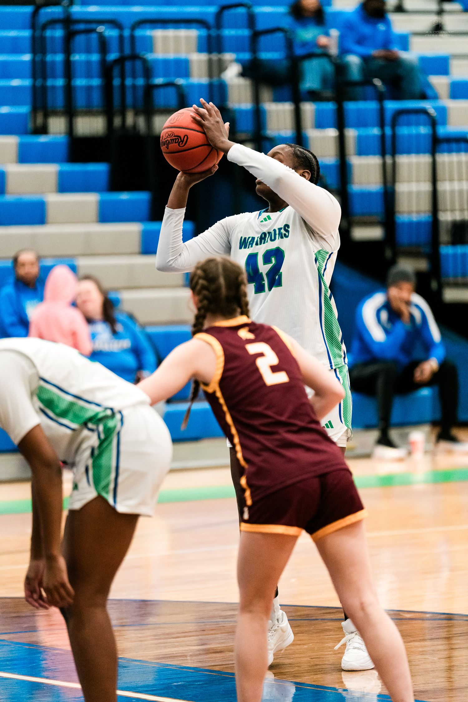 A Warriors player number 42 shoots a free throw during a girls high school basketball game.