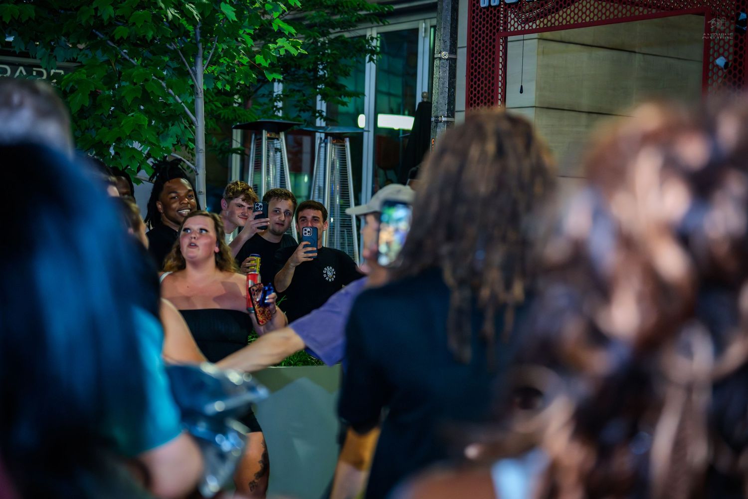 Crowd of young people watching outdoor nighttime performance or event.