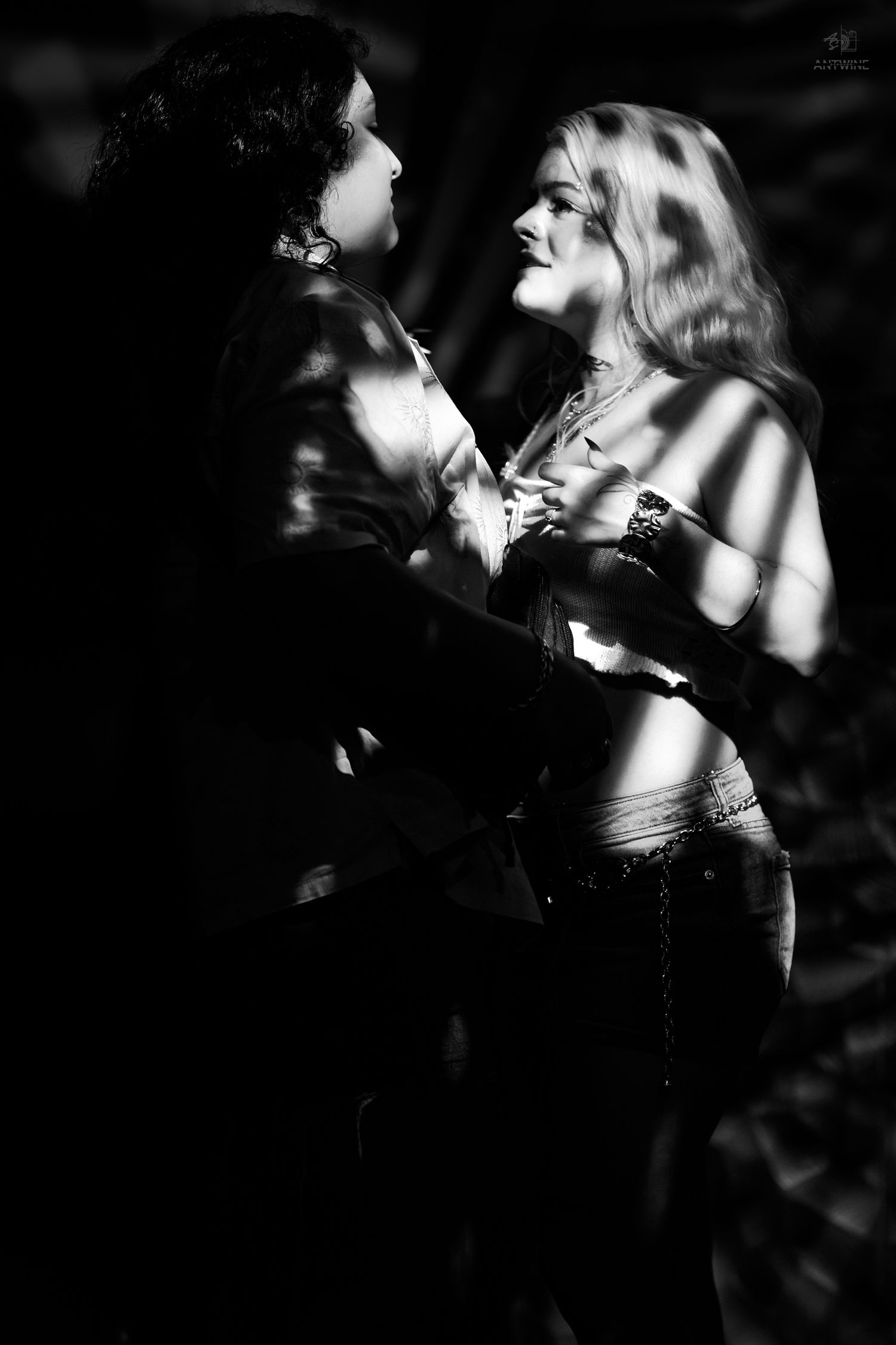 Black and white romantic couple portrait with dramatic shadow lighting, man and woman gazing at each other intimately.