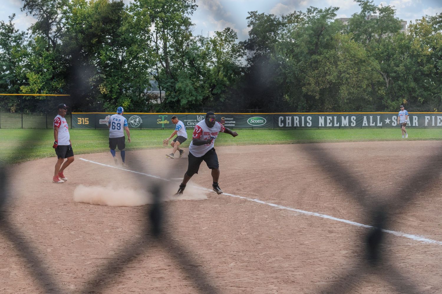 Softball players competing at a base during a game at Chris Nelms All-Star field.