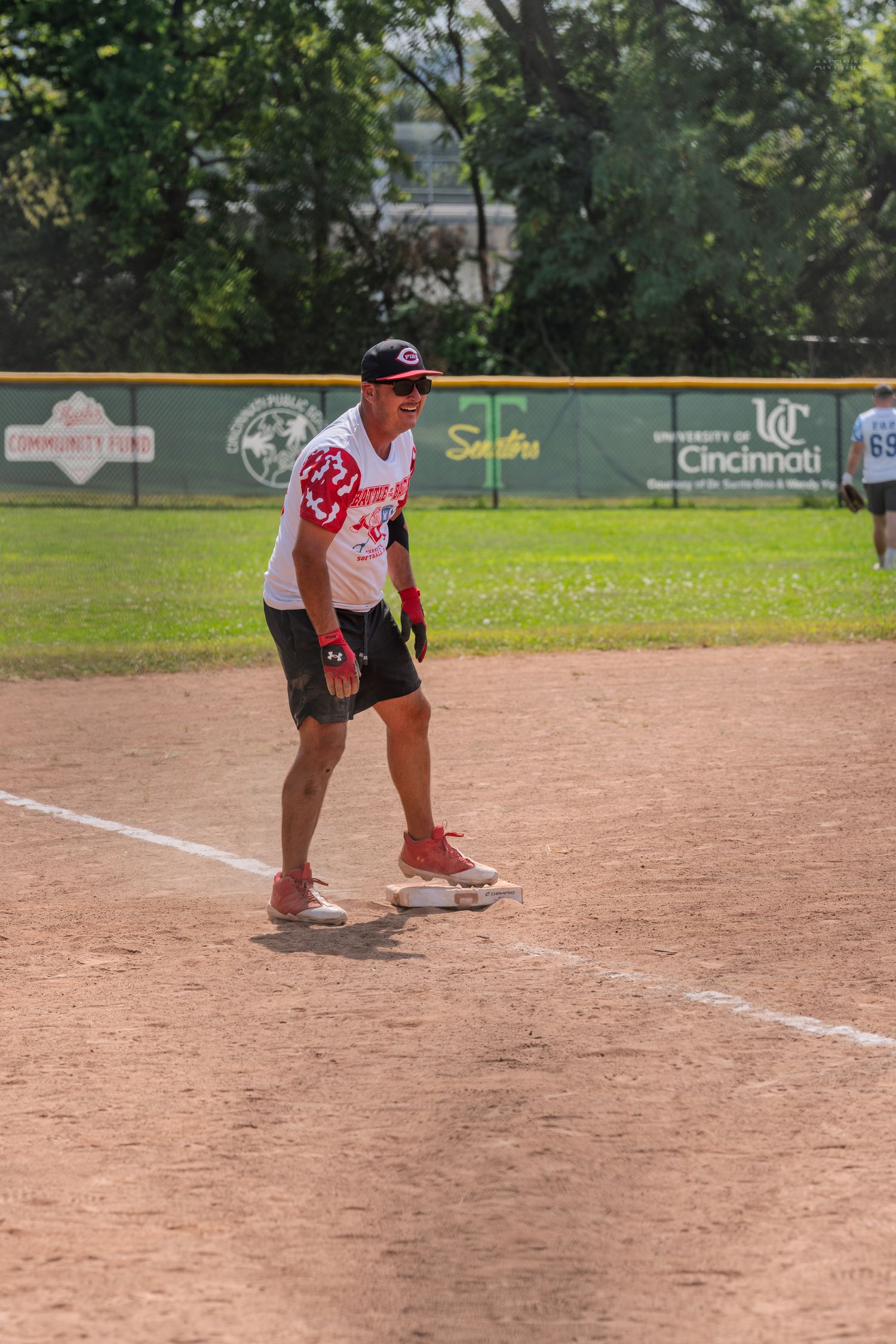 Male softball player standing on base at Chris Helms All-Star Field during charity game.