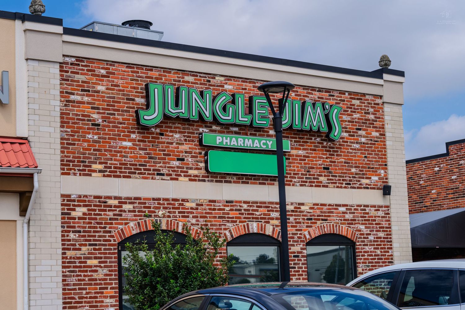 Jungle Jim's Pharmacy exterior with green signage on a brick building facade.
