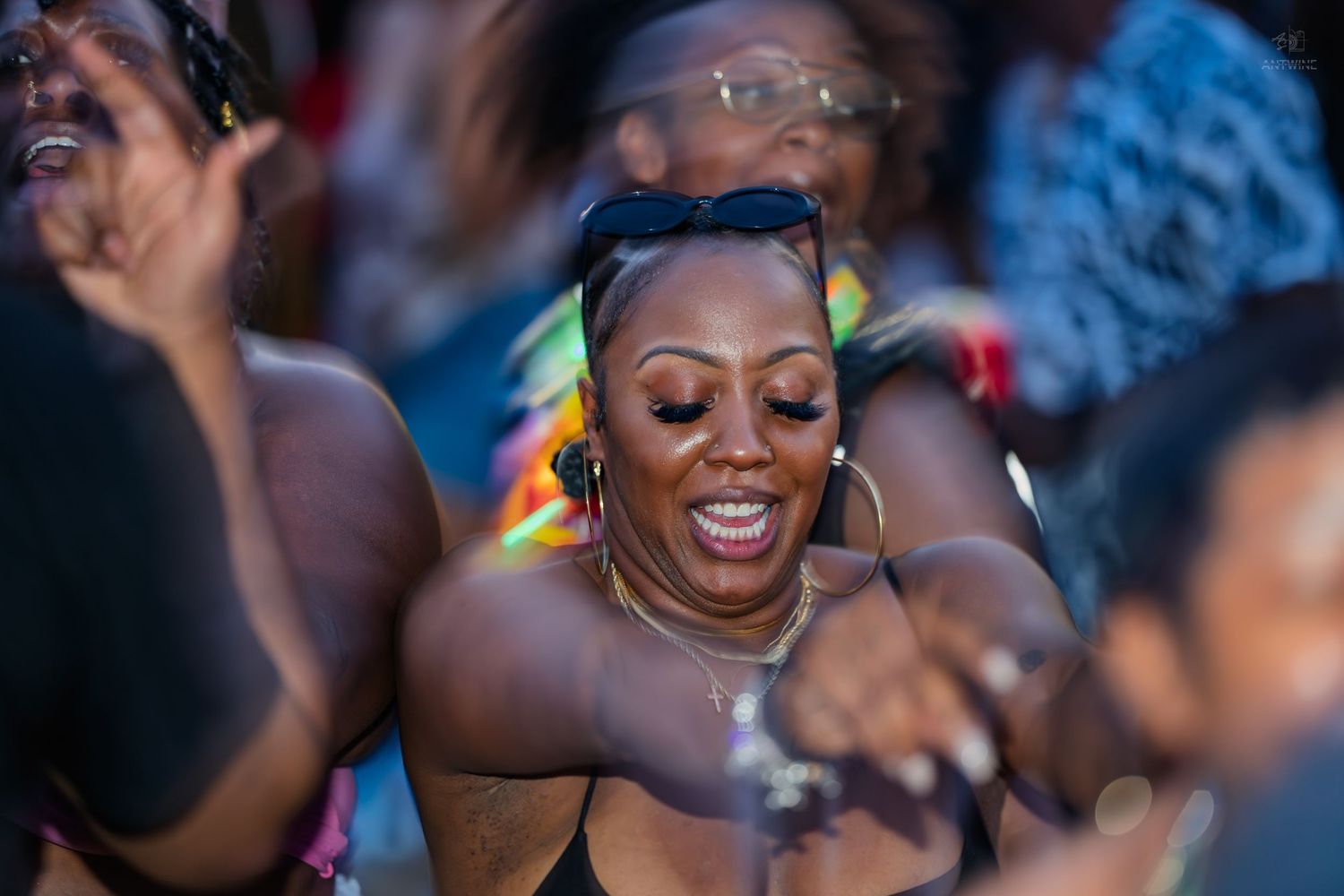 Woman smiling and dancing joyfully in crowd at vibrant Juneteenth outdoor celebration event.
