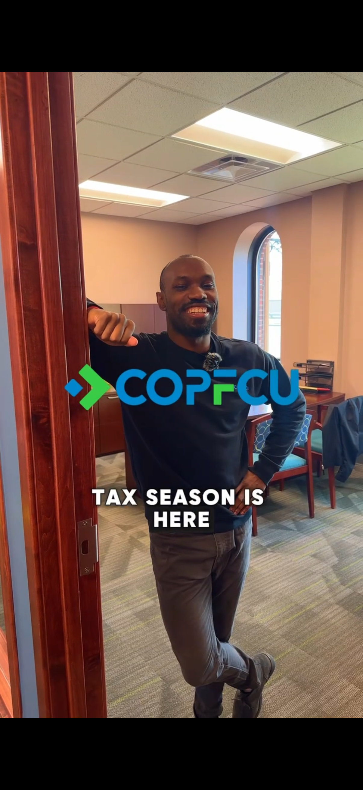 Man smiling at COPFCU credit union office during tax season promotion event.