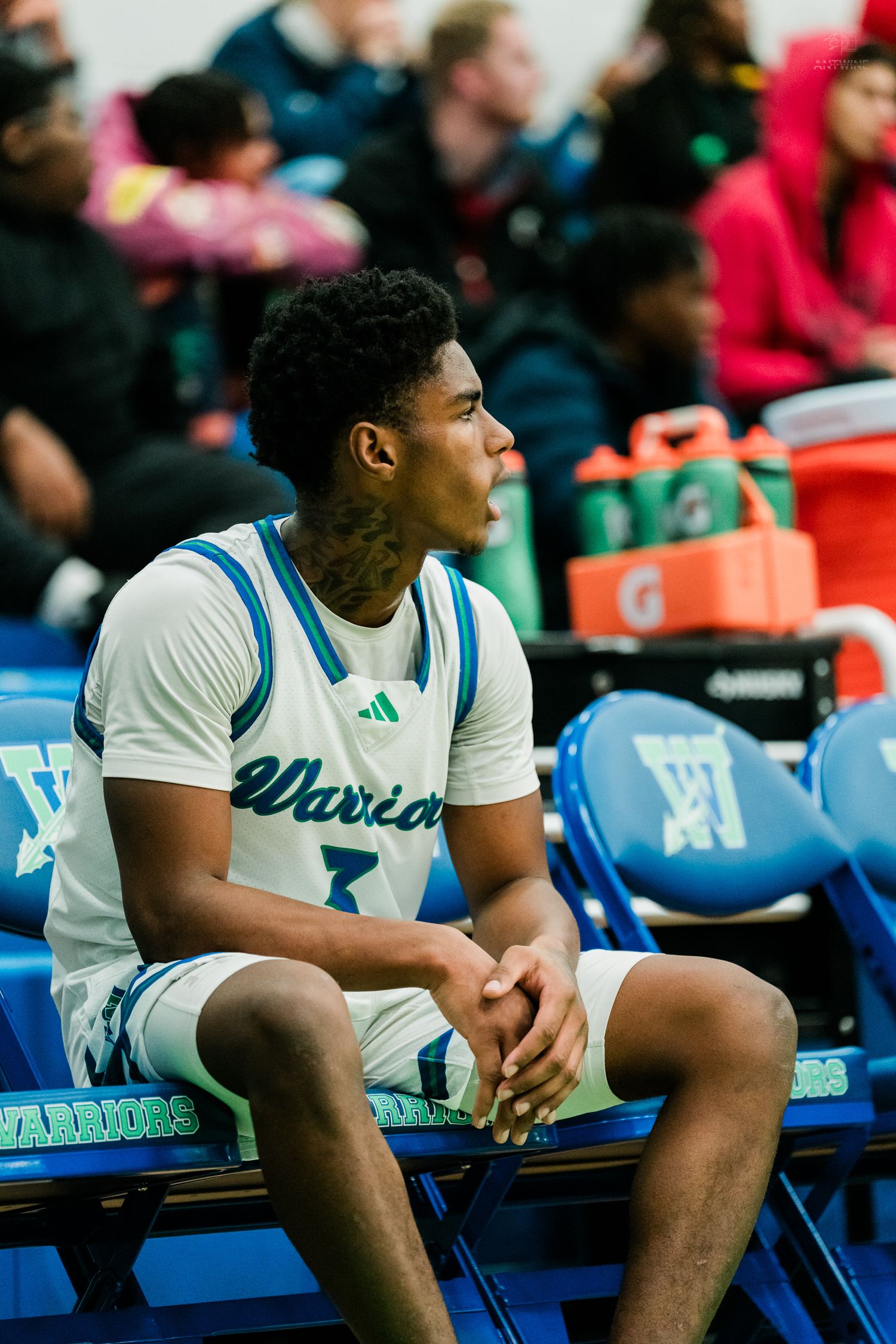 Winton Woods Warriors basketball player #3 sits on the bench during a high school basketball game.
