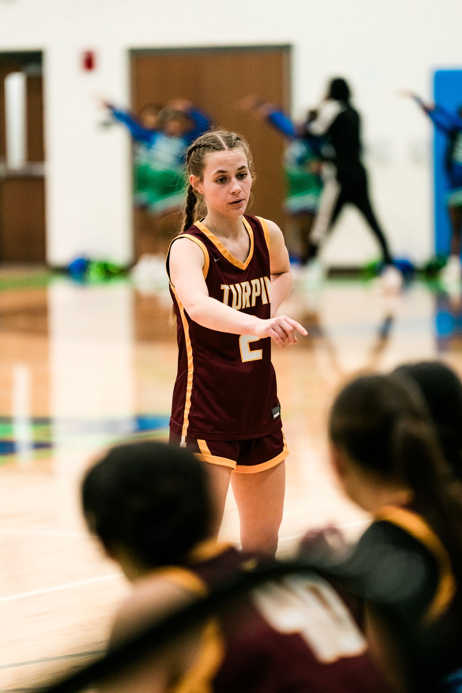 Turpin girls basketball player #2 in maroon uniform communicates with teammates during a game.