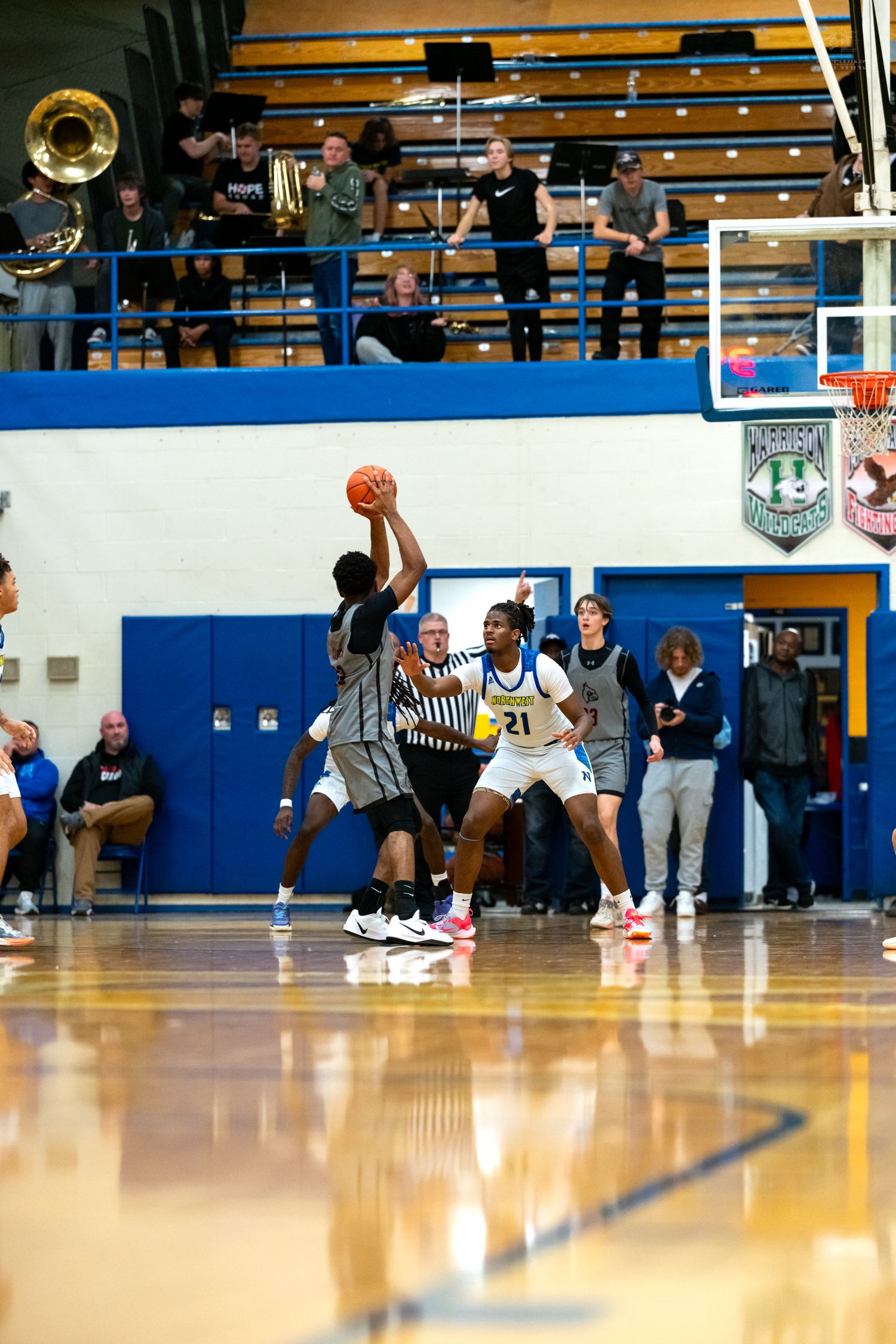 High school basketball player shoots over defender #21 during a Northwest home game.