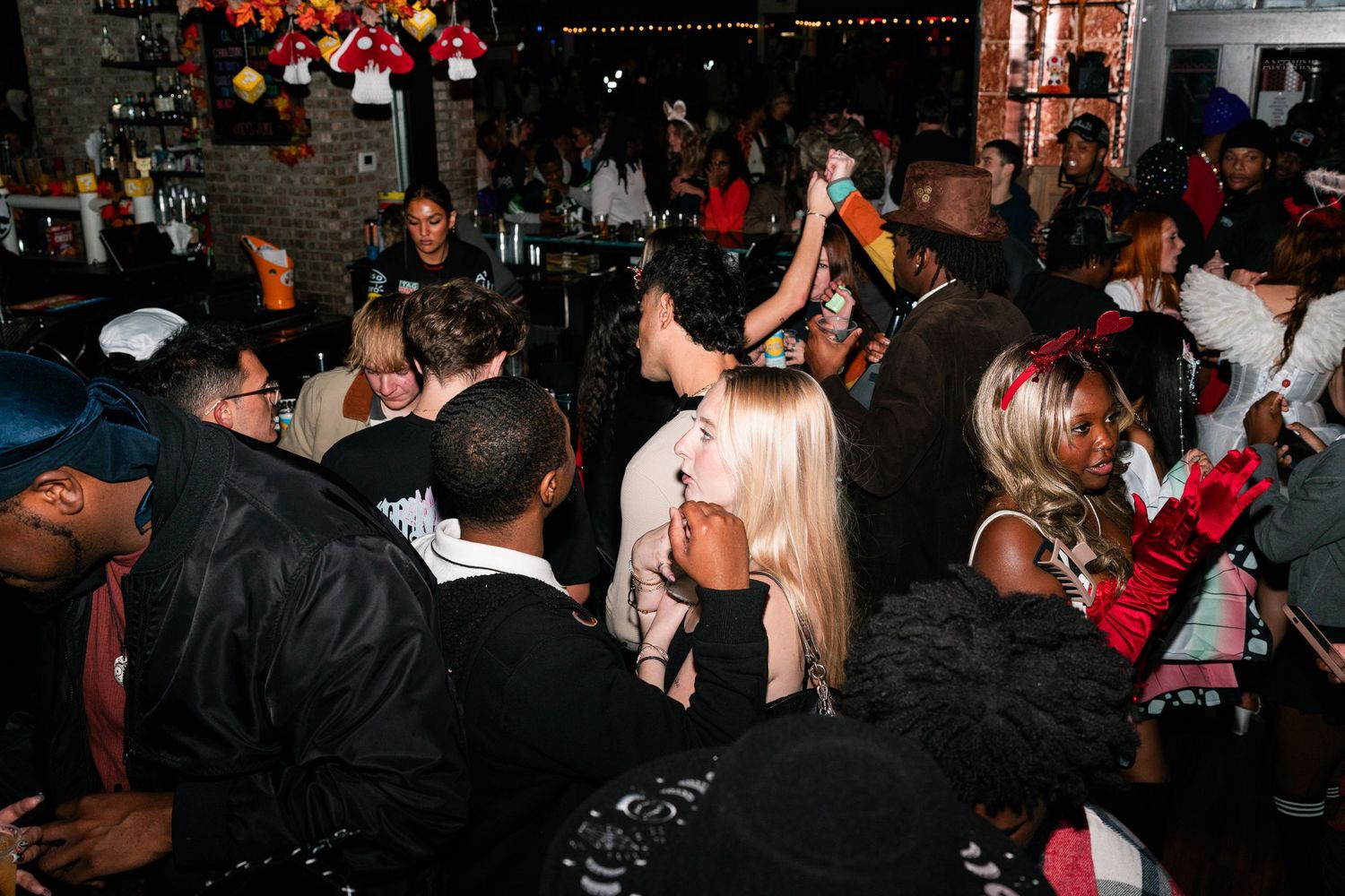 Diverse crowd dancing and socializing at a festive indoor party event.