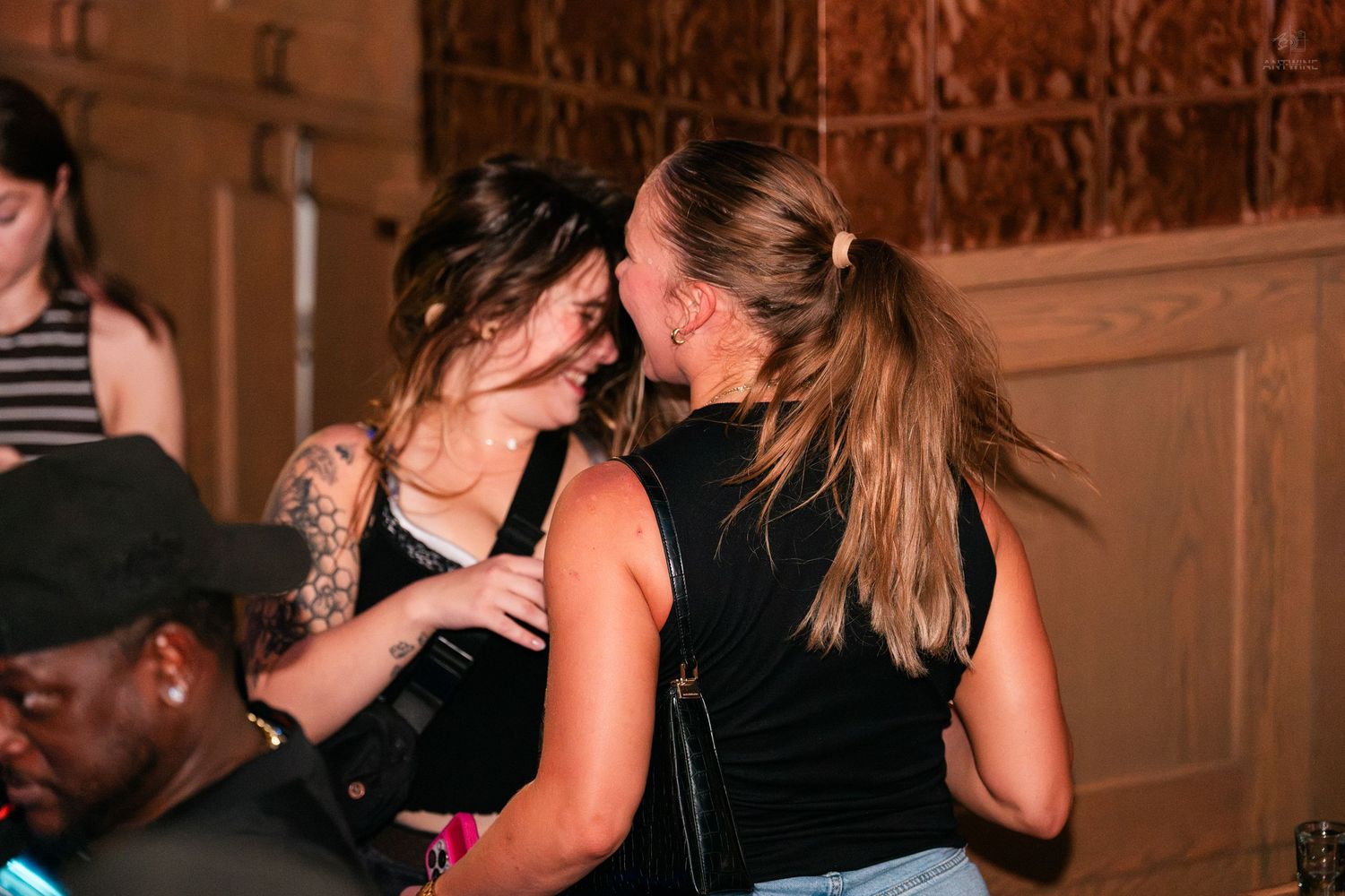 Two women sharing a close moment together at an indoor party venue.