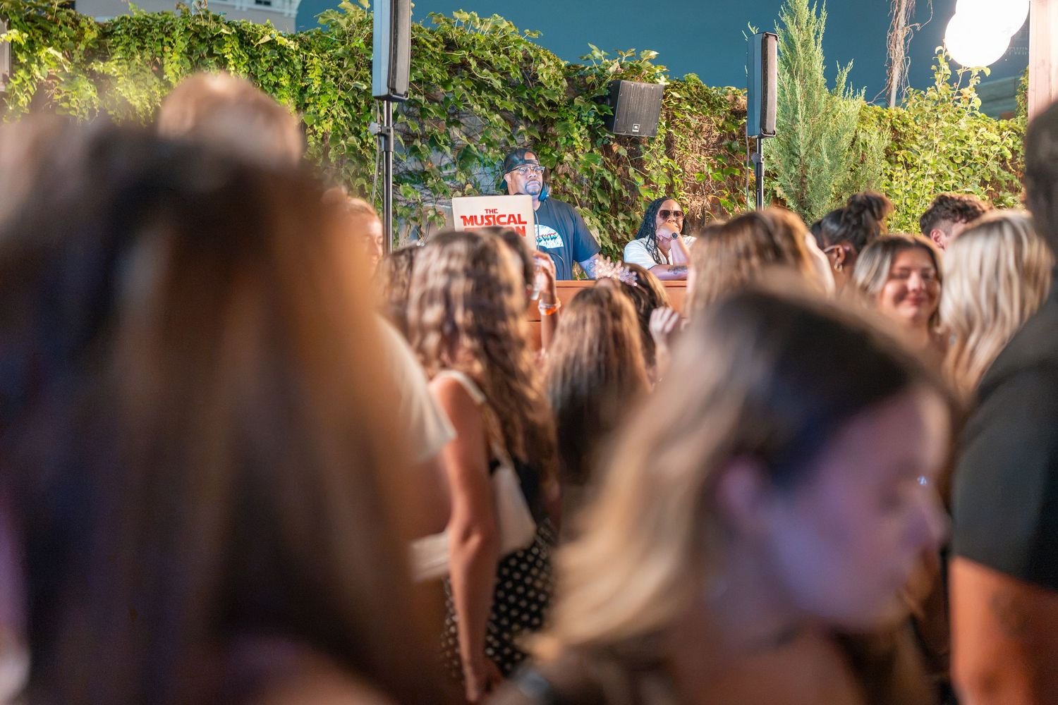 Large crowd of women gathered at an outdoor daytime social event or concert.