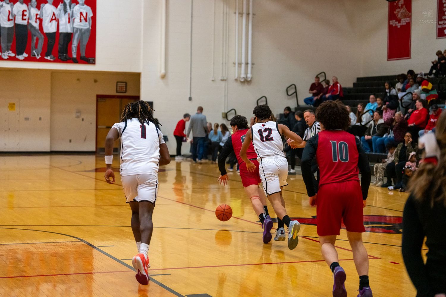 Colerain players number 1 and 12 advance the ball during a high school basketball game.
