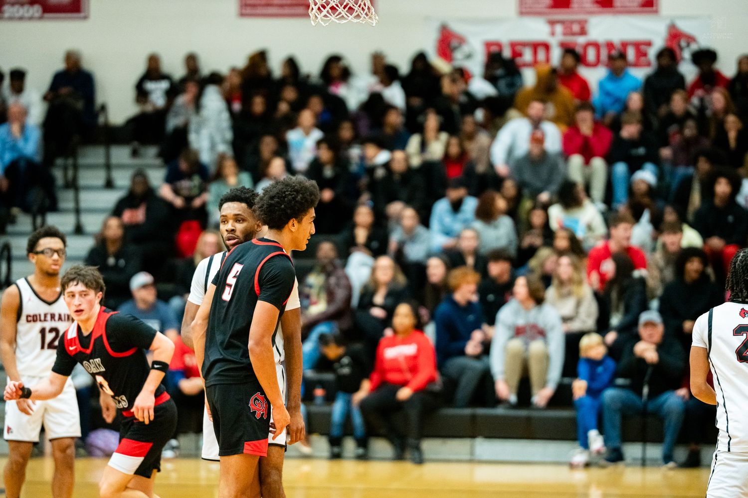 Colerain Cardinals players walk court during high school basketball game in front of packed Red Dome gymnasium crowd.