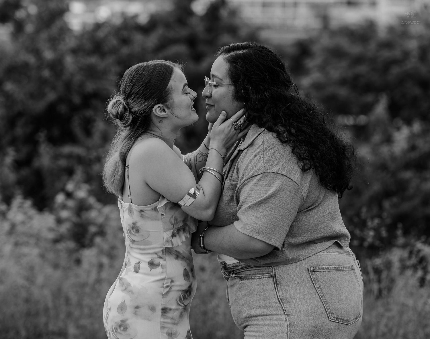 Two women sharing an emotional embrace outdoors in black and white photography.