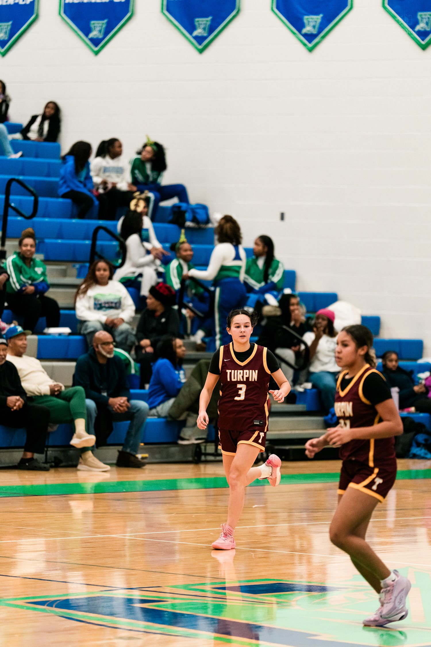 Turpin girls basketball player number 3 in maroon uniform runs during high school game.