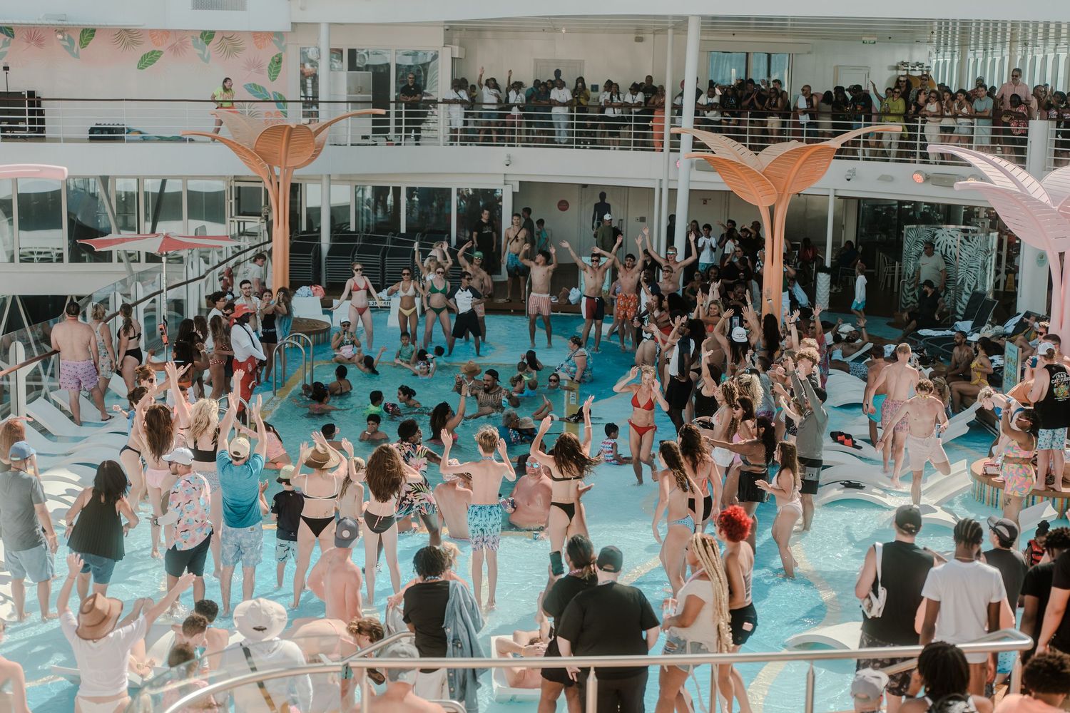 Aerial view of a lively cruise ship pool party with dancing crowds.