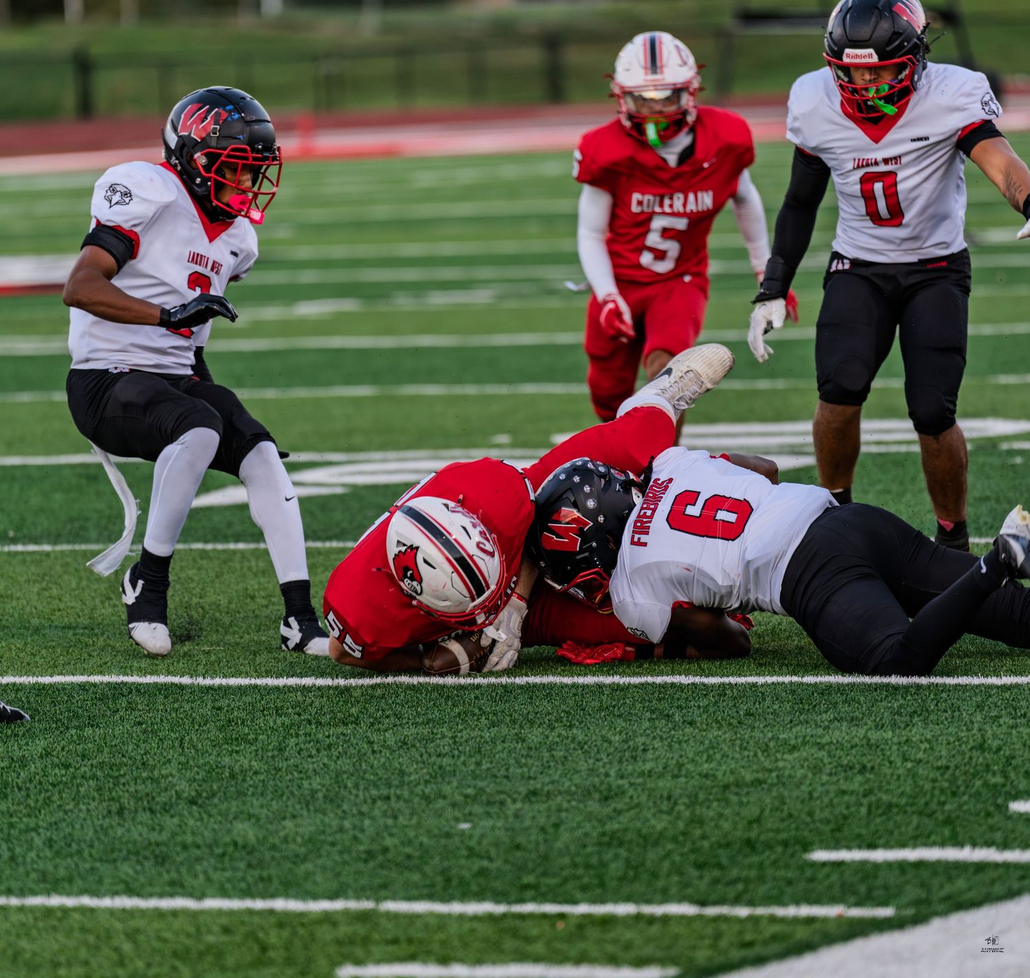 Colerain high school football player tackled on the field during a competitive game under stadium lights.
