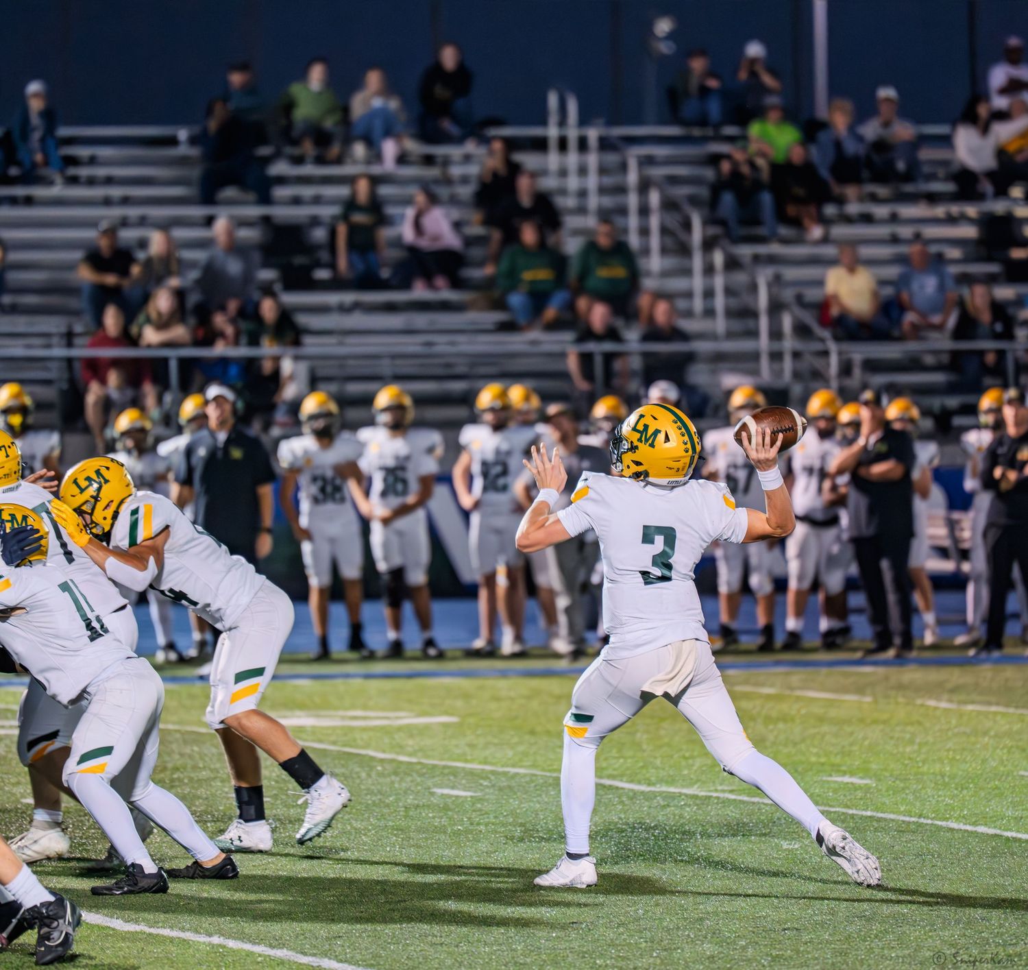 Little Miami quarterback #3 prepares to throw a pass during a high school football game.