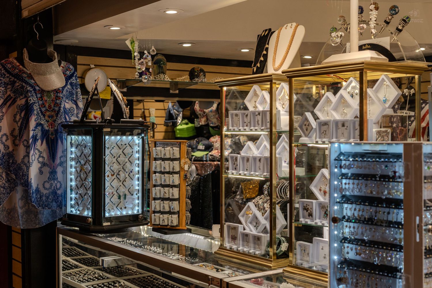 Elegant jewelry store display cases with illuminated glass showcases featuring accessories and trinkets in a boutique shop.