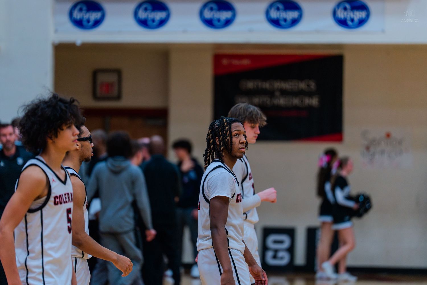 Colrain high school basketball players walk on court during game.