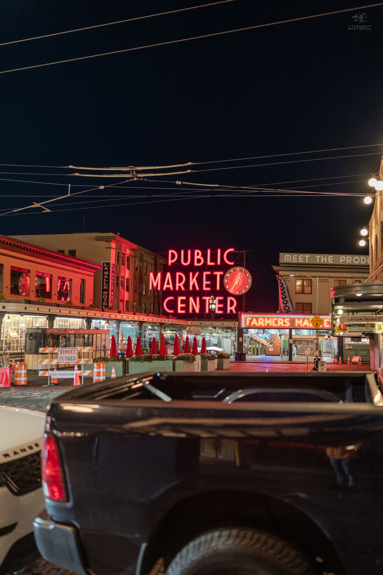 Pike Place Public Market Center iconic neon sign glowing red at night in Seattle.