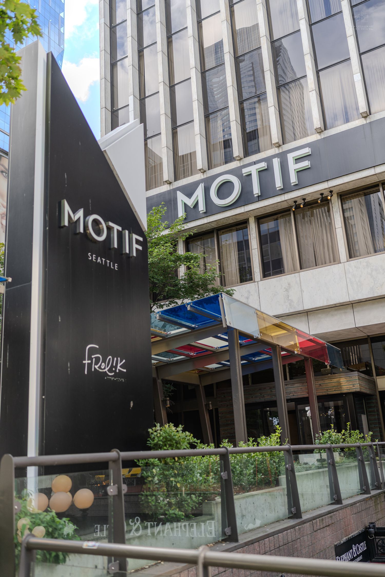 Motif Seattle hotel entrance sign with Frolik restaurant branding on a downtown Seattle street.