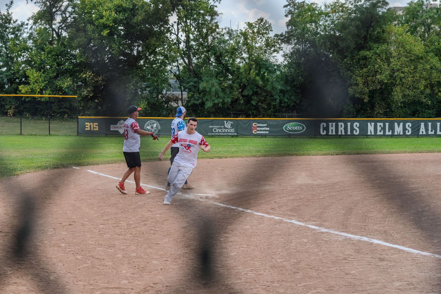Softball player rounding first base during a game at Chris Nelms All-Star field.