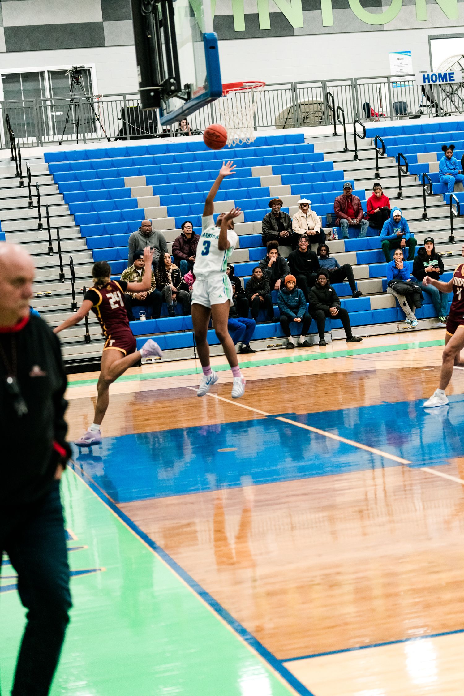 Girls basketball player #3 in white Harbors uniform shoots a jumper over a maroon-clad defender.