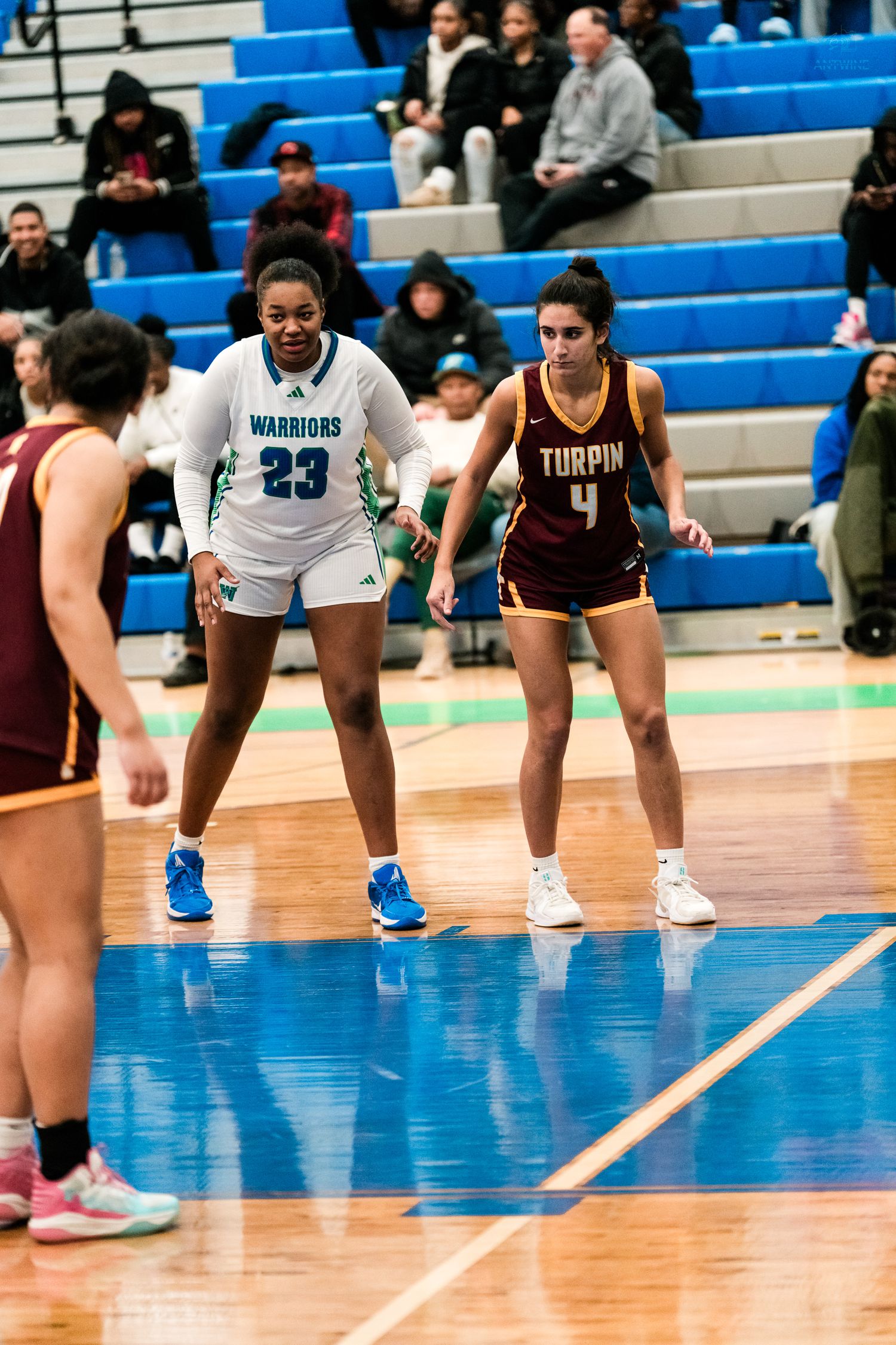 Warriors #23 and Turpin #4 face off during a girls high school basketball game.