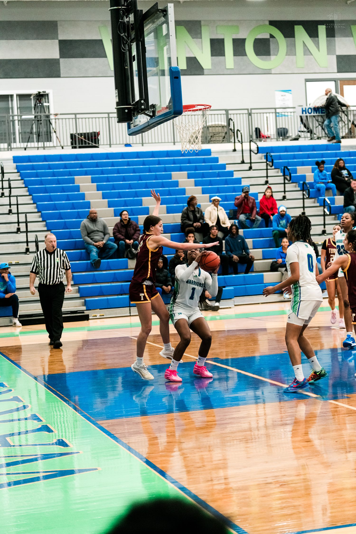 Winton Woods girls basketball player #1 drives to the basket against a Turpin defender.