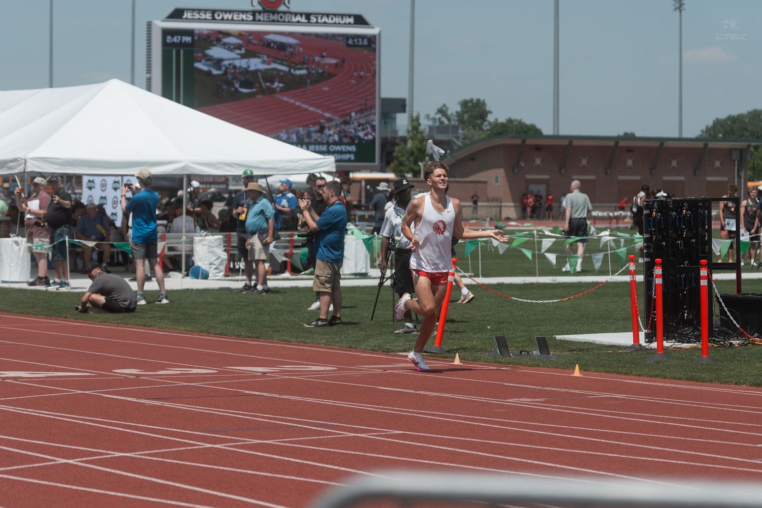 Lone runner crosses the finish line at Jesse Owens Memorial Stadium during a track and field competition.