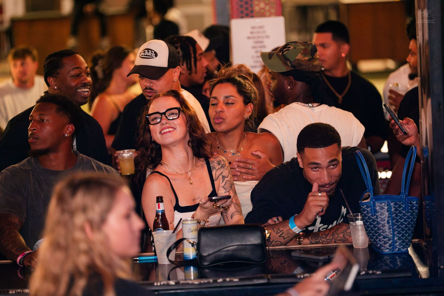 Group of diverse friends smiling and socializing at an outdoor nightlife venue.