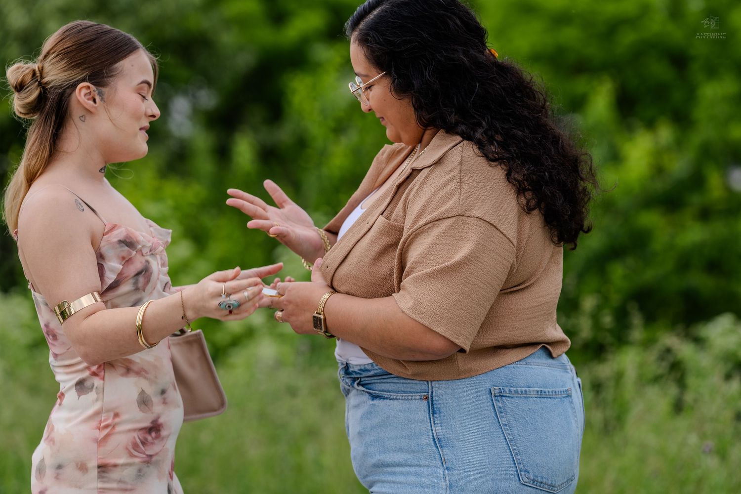 Two women sharing a meaningful moment during an outdoor engagement proposal.