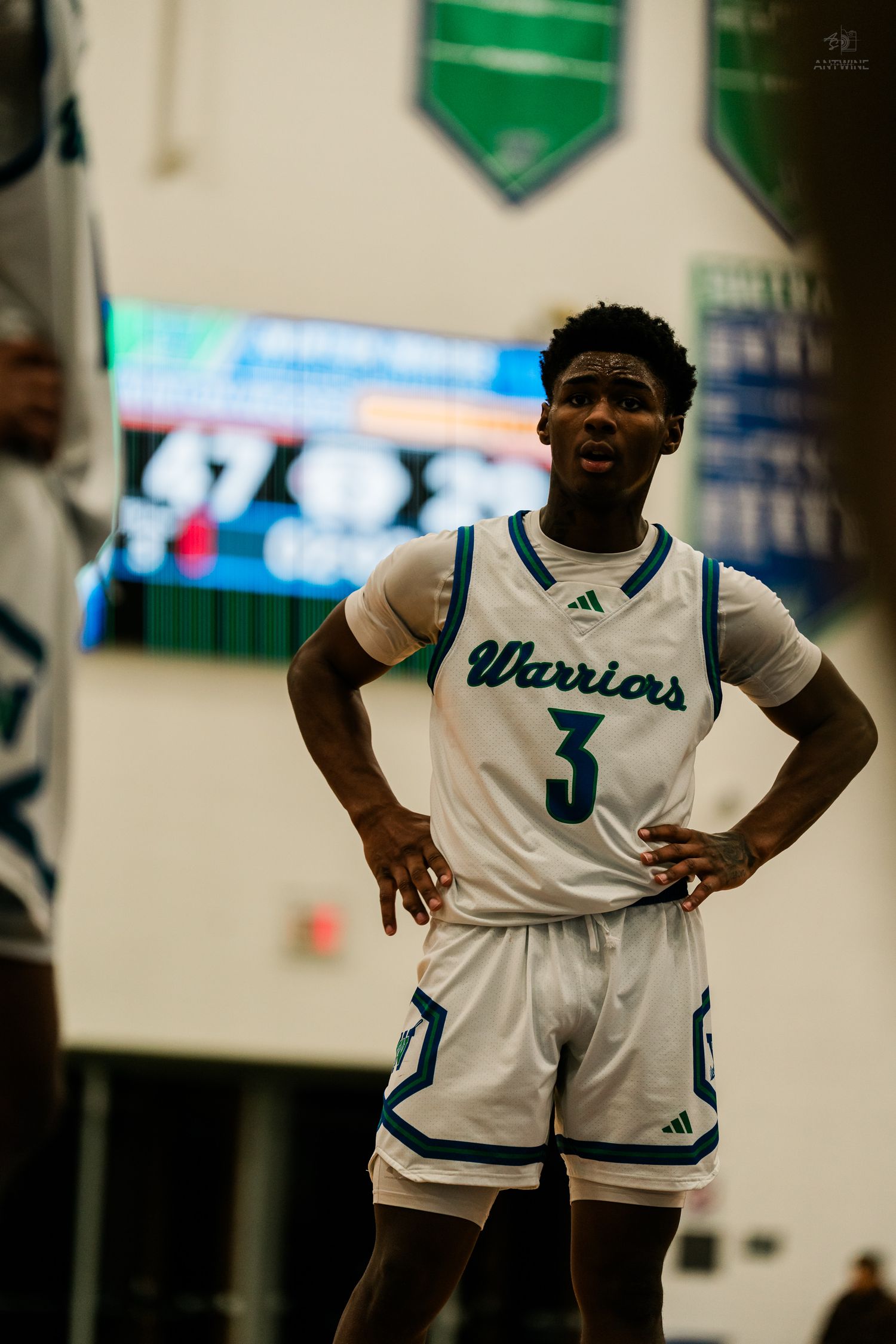 Warriors basketball player #3 in white Adidas uniform stands with hands on hips.