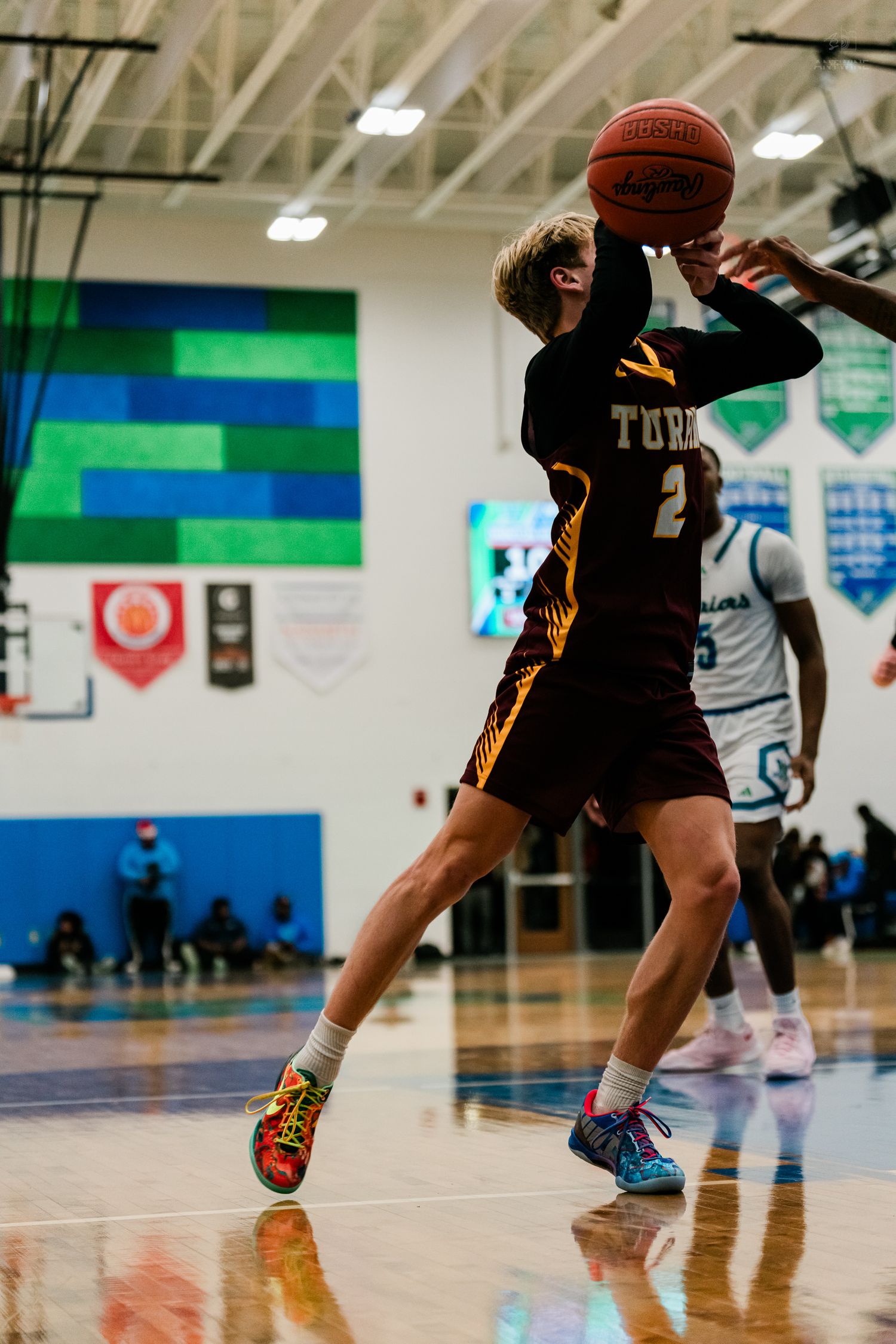 Turpin high school basketball player #2 rises for jump shot during varsity basketball game.