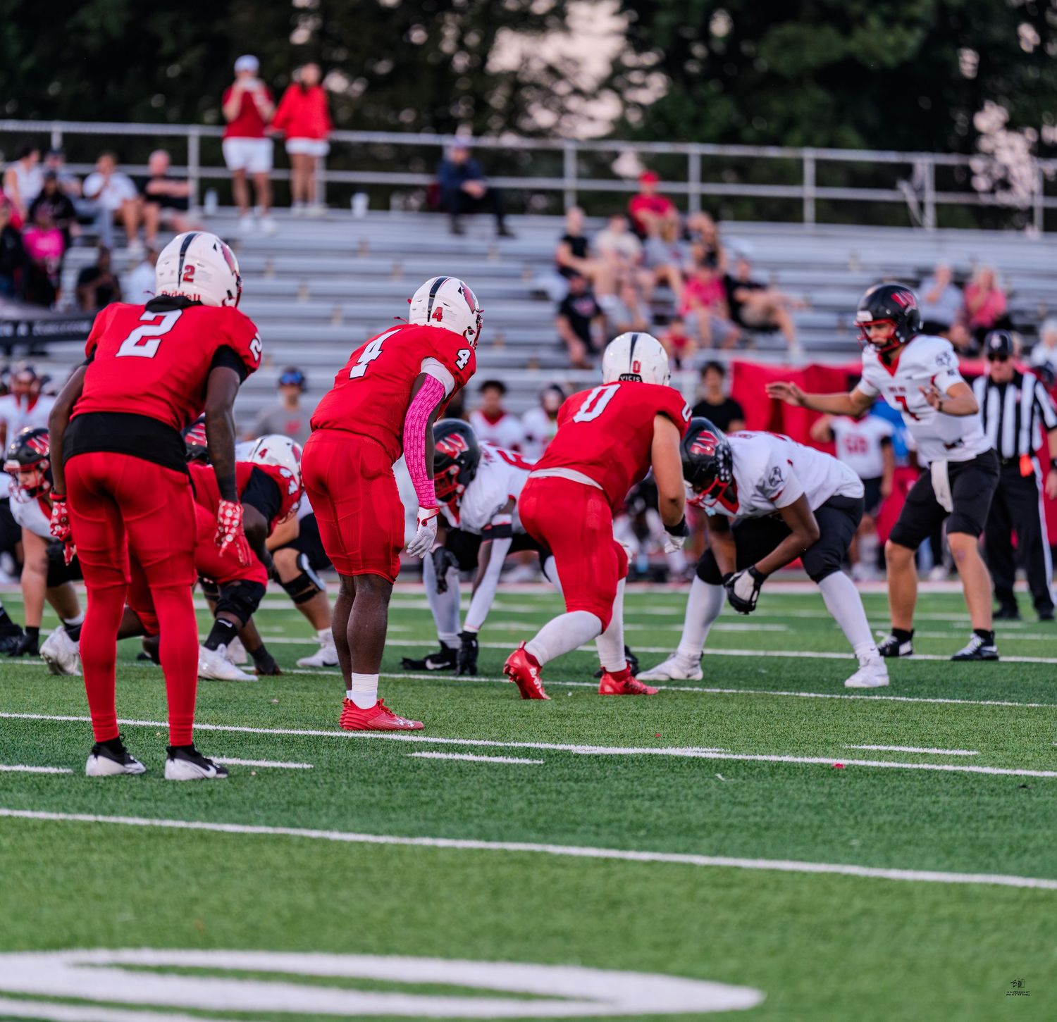 Colerain Cardinals football team lines up at the line of scrimmage during a night game.