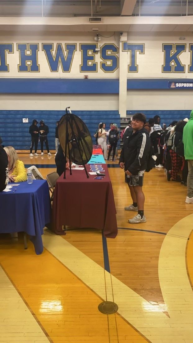 Students browse tables at a Southwest Knights high school gymnasium college or career fair event.